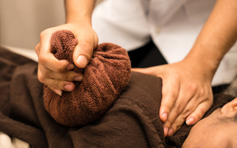 Doctor to apply a hot compress for Thai massage treatment